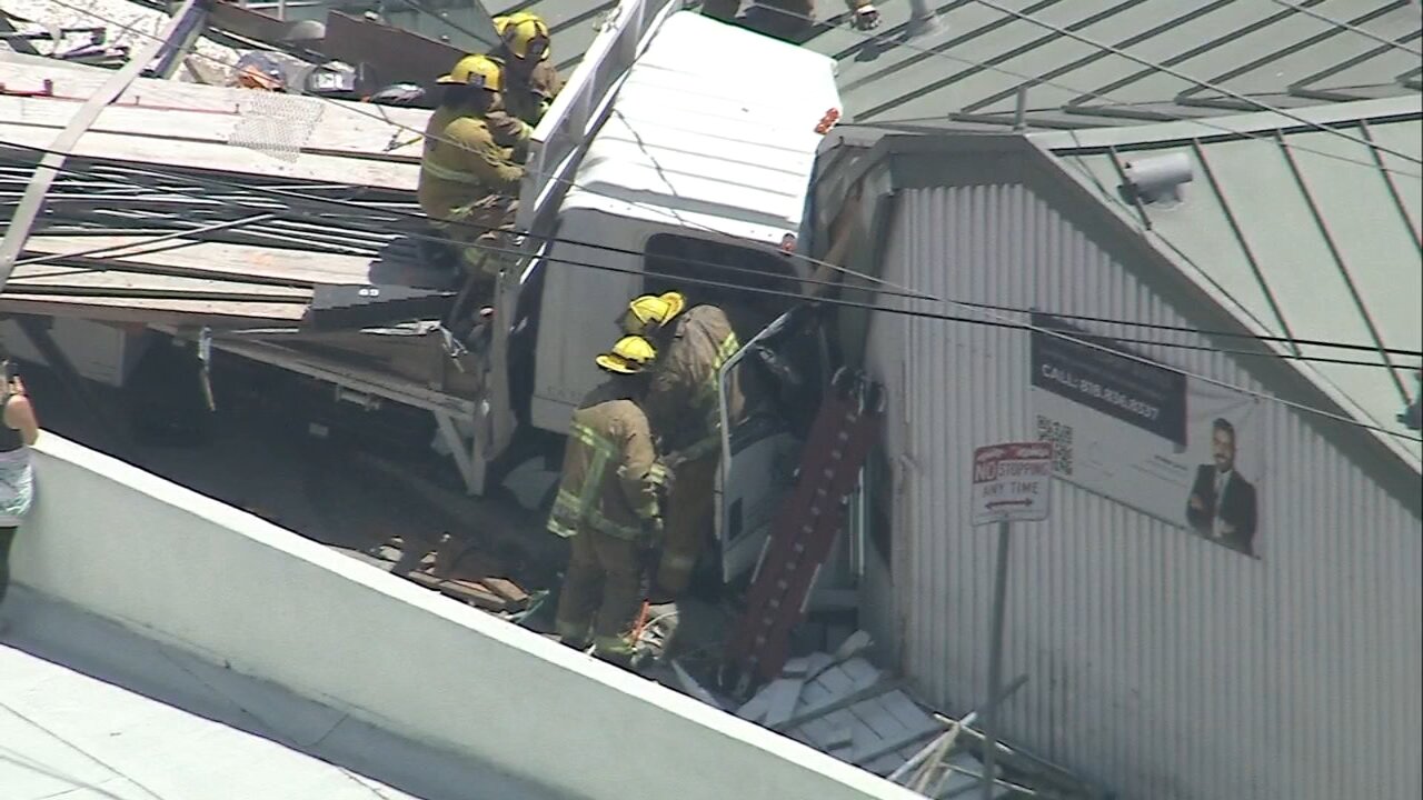 Firefighters rescue trapped driver after flatbed truck slams into building in Pacific Palisades