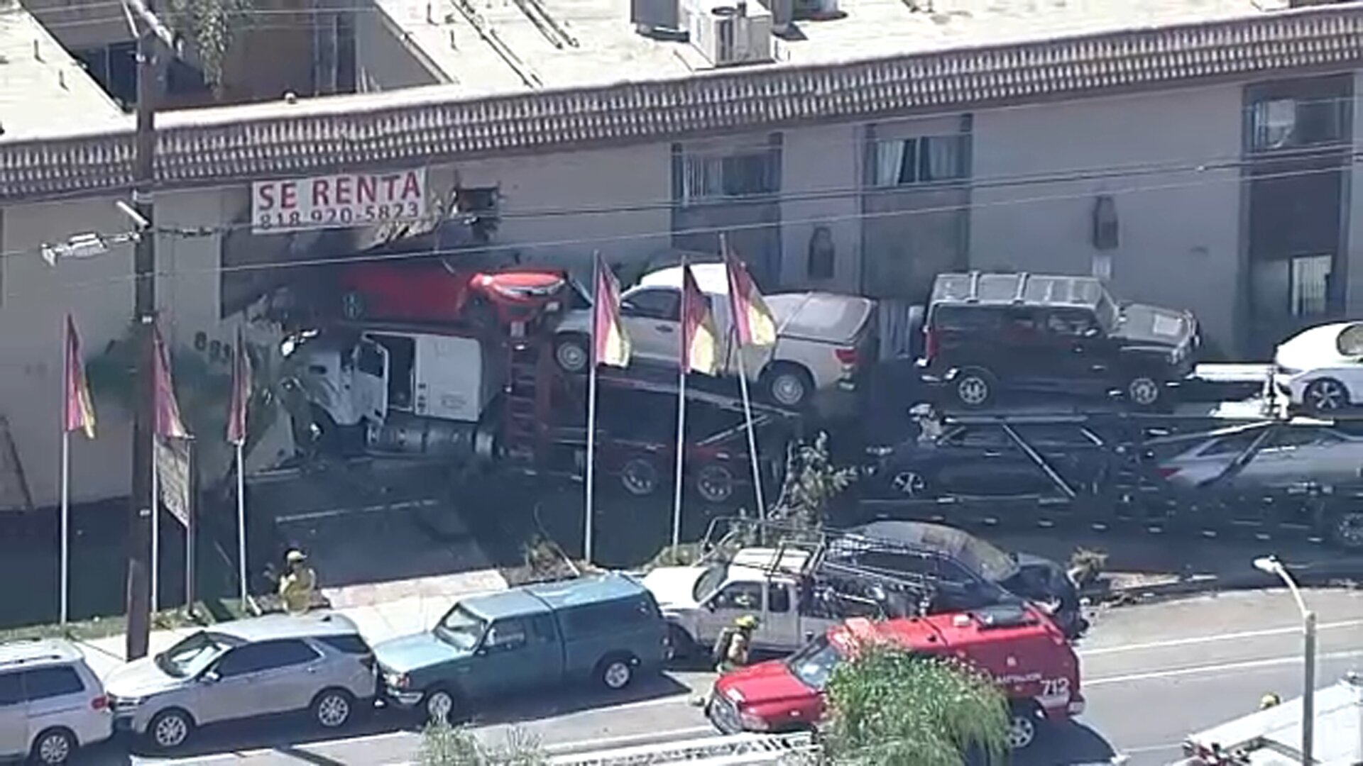 At least 3 hurt after semi-truck carrying vehicles crashes into apartment building in Panorama City