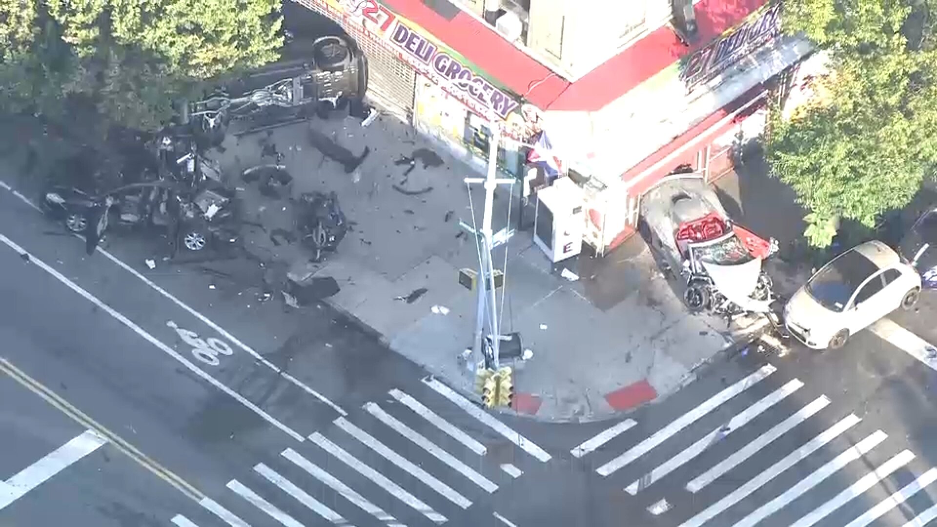 Pedestrian, 2 others hurt when 2 cars crash and jump curb in Inwood; parked vehicles also damaged
