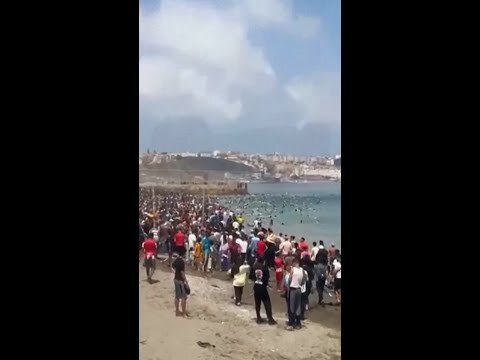 Thousands of Moroccan migrants force their way into Spain
