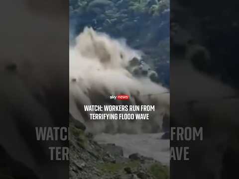 Workers run from terrifying flood wave