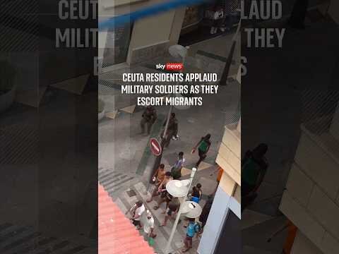 Ceuta residents applaud military soldiers as they escort migrants