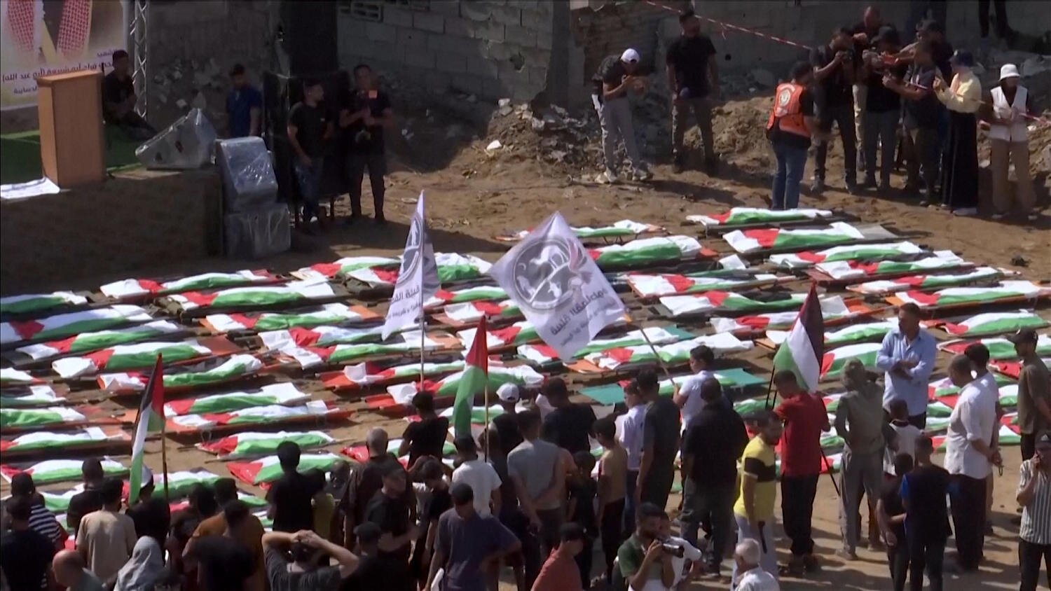 Mourners hold a mass funeral for 112 recovered bodies in Gaza