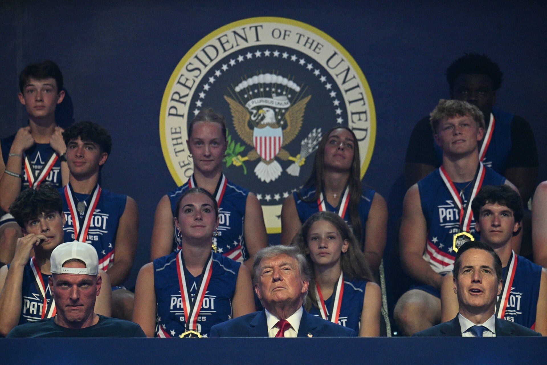 Pat McAfee joins Donald Trump during 2026 Patriot Games entrance, sits next to him during event