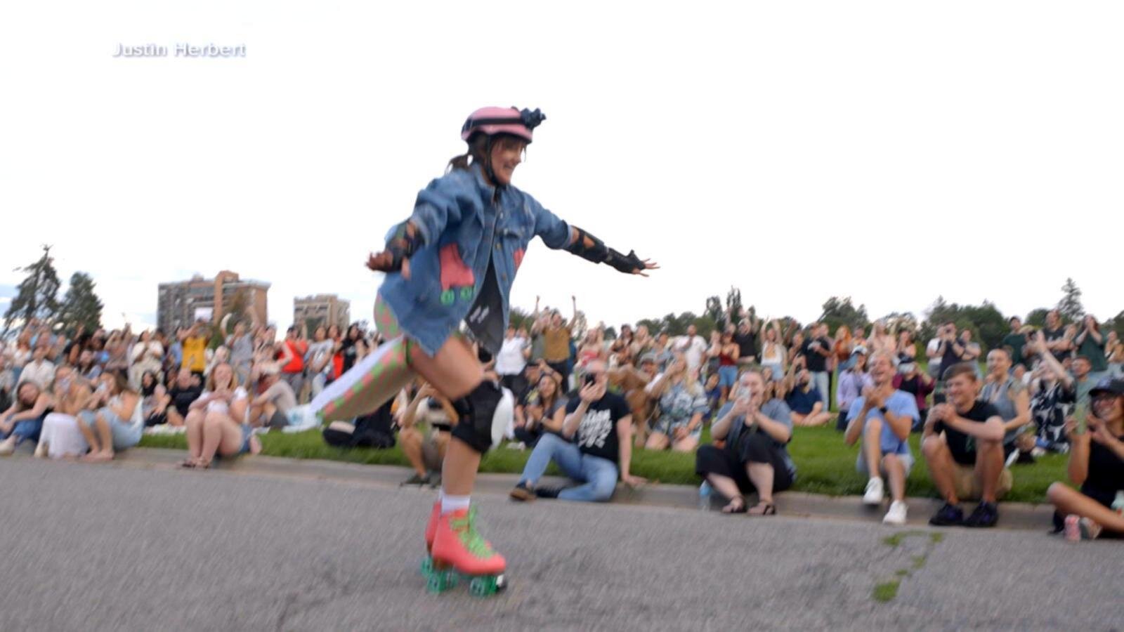 Woman roller skates for the first time before a large crowd